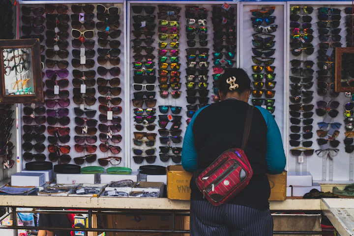 A customer browsing a wall of eyeglasses in a shop