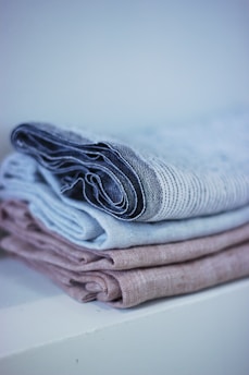 Close-up of soft, neatly folded linen sheet sets in calming neutral tones.