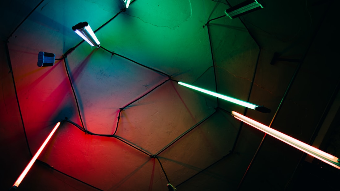 Neon lights in various colors, including red, green, and blue, are attached to a hexagonal pattern on the ceiling, creating a glowing geometric design.