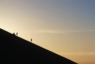 A vibrant group trekking through the rugged hills of Sindh at sunrise.