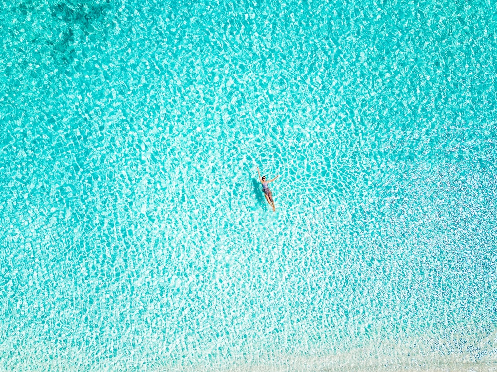 Fotografía de vista aérea de una persona nadando en la playa