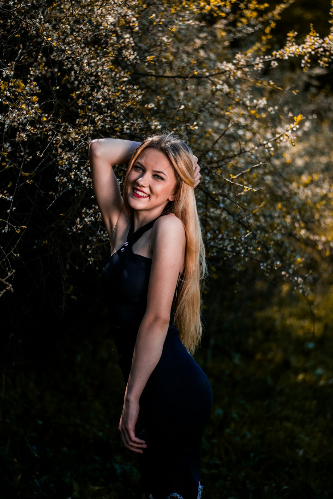 smiling woman standing near tree