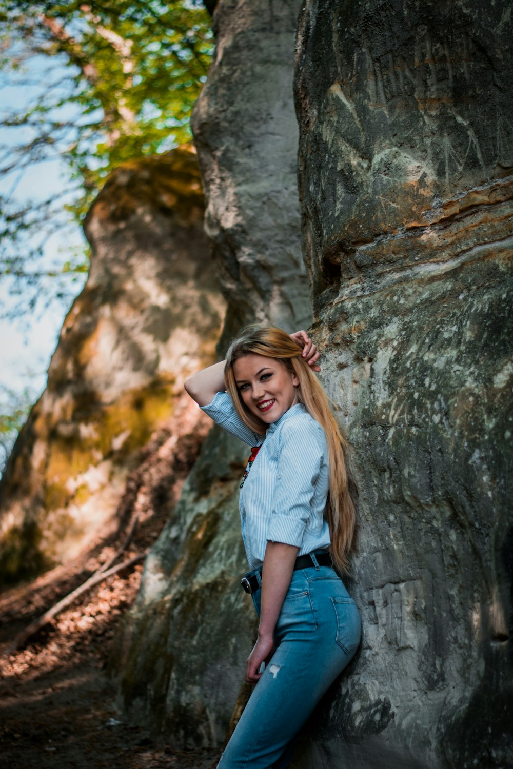 smiling woman leaning on rock formation