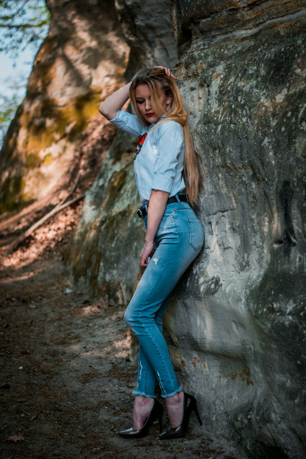 woman leaning on gray rock