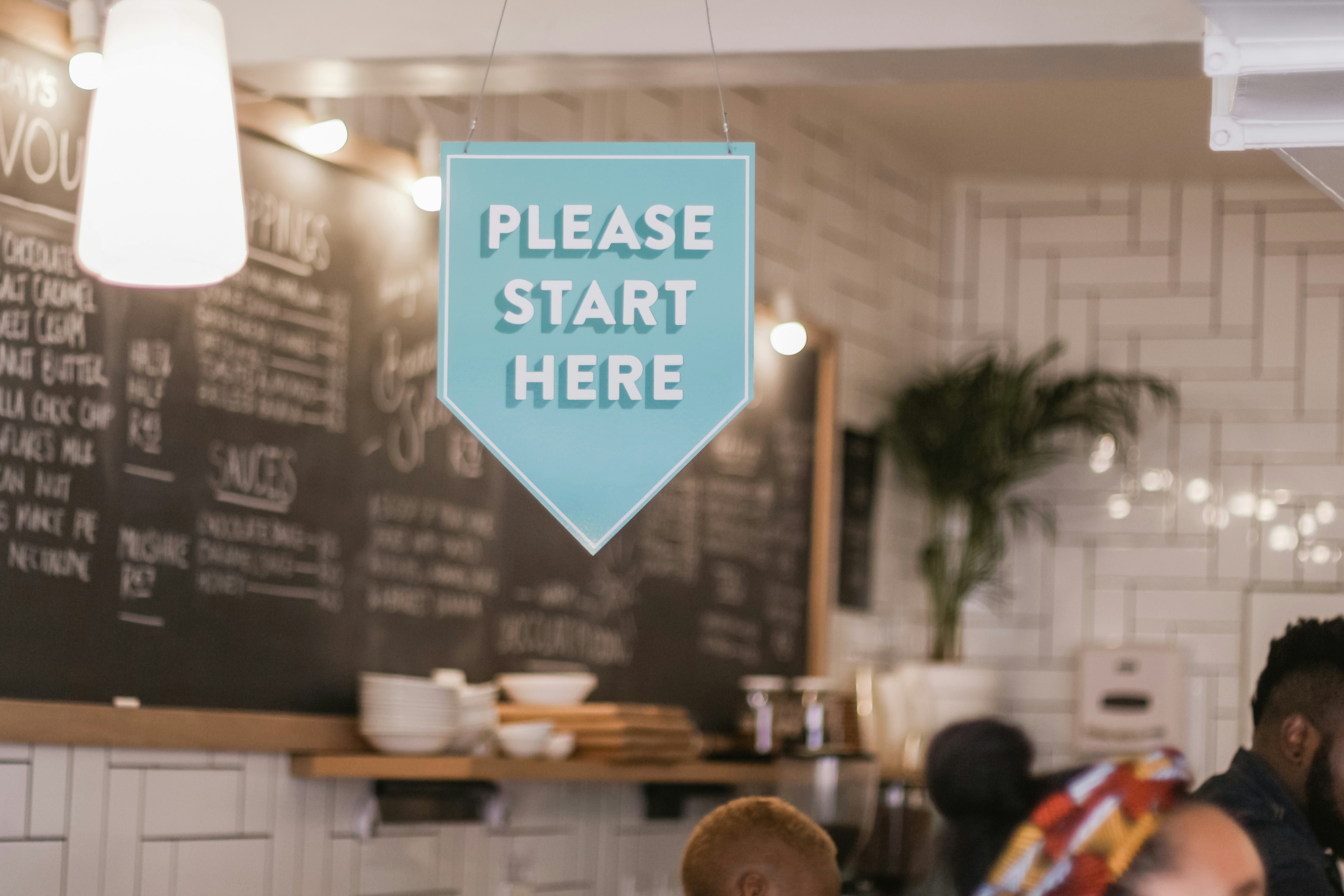 New restaurant sign pointing to where guests can line up to order their food from a POS system