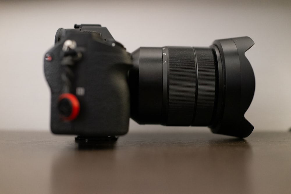 black SLR camera on brown wooden surface