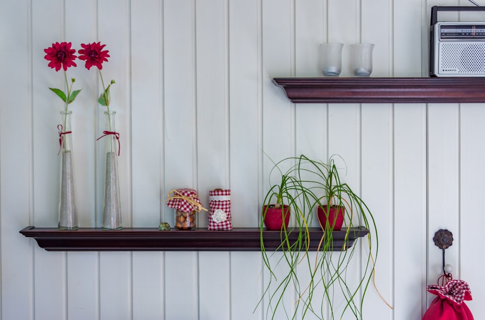 four vases on brown wooden floating shelf