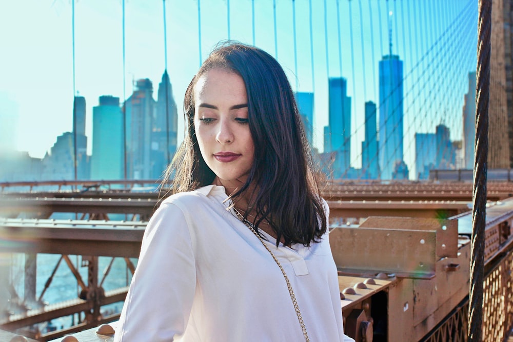 woman in white long-sleeved top standing in bridge