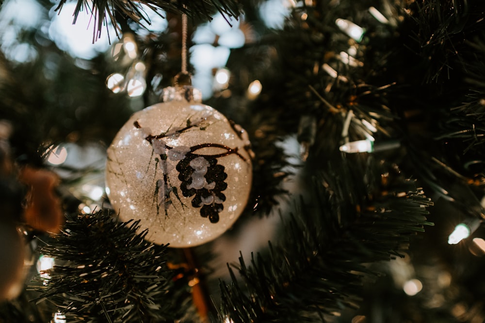 close view of white Christmas bauble hanging on Christmas tree