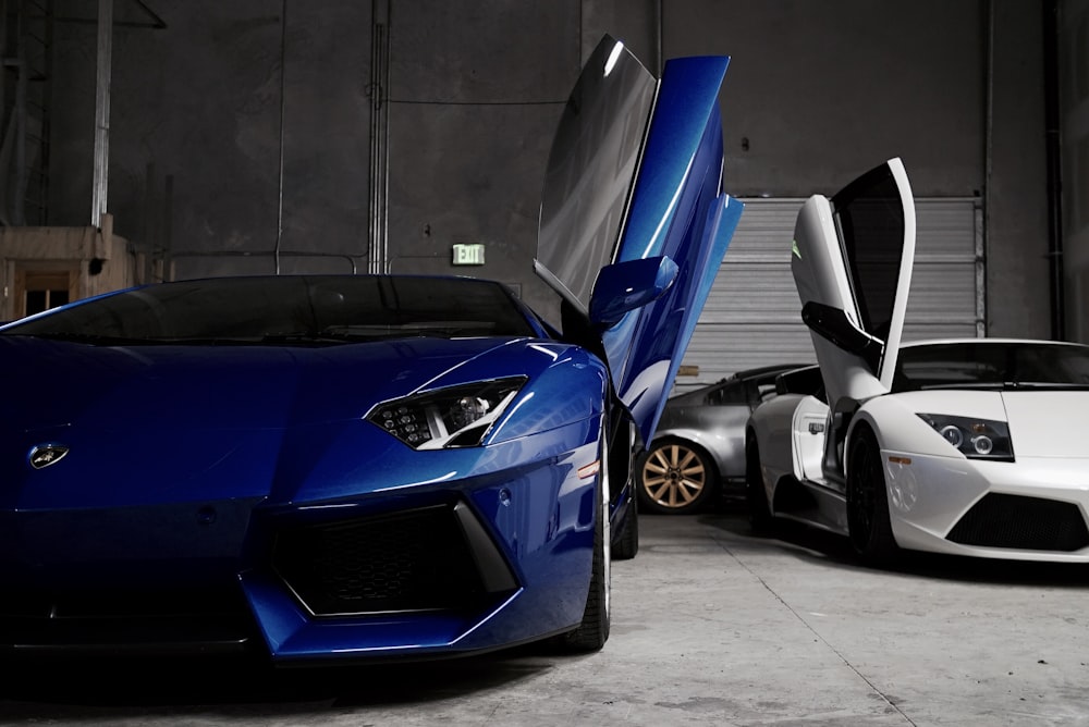 dois veículos Lamborghini brancos e azuis dentro da garagem