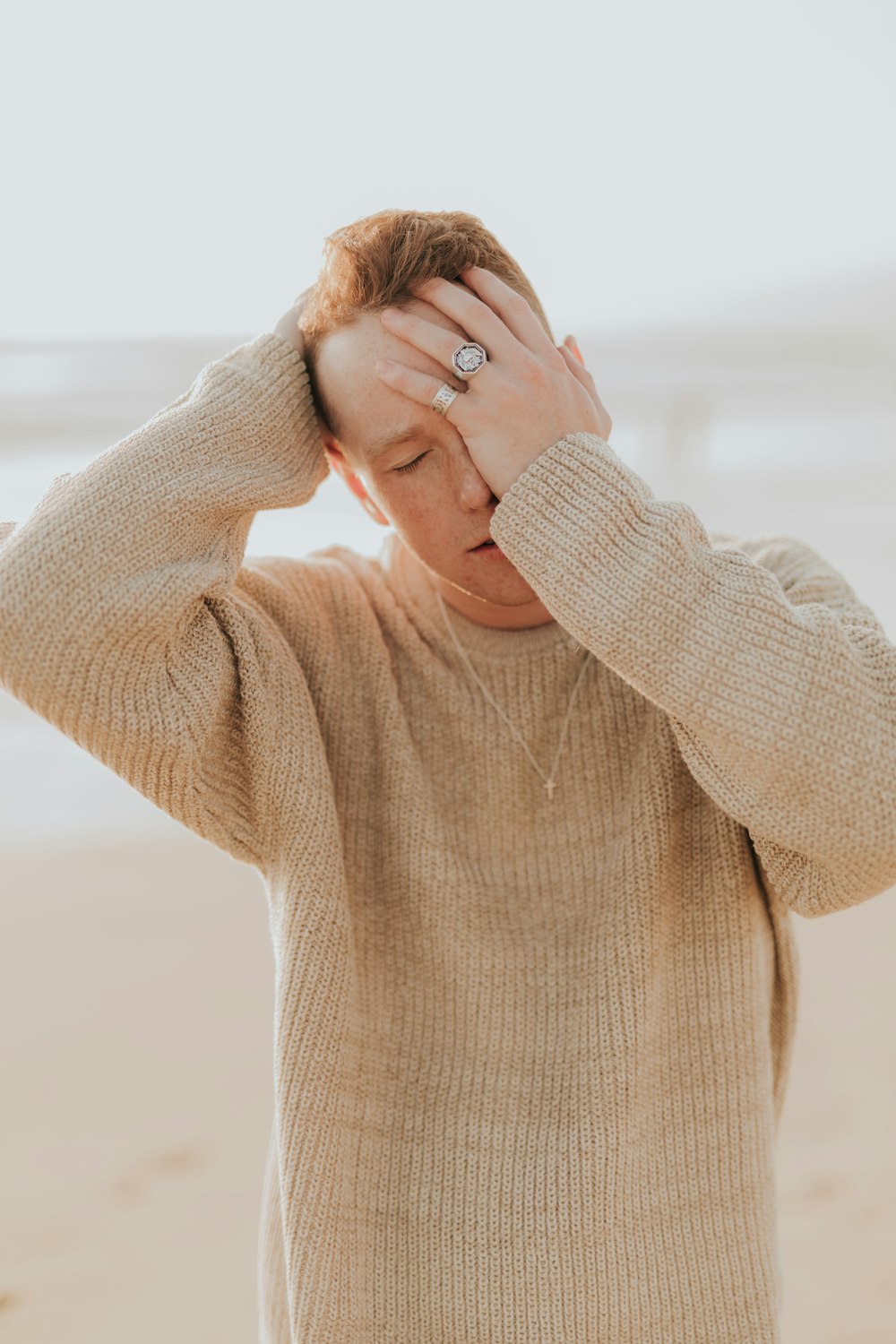 uomo che copre l'occhio sinistro con la mano durante il giorno