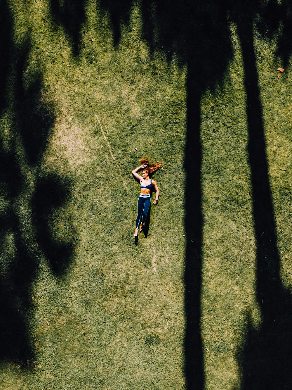 woman lying on green grass during daytime