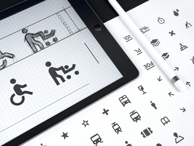 A close-up of a tablet displaying a symbol-based communication grid used for augmentative communication
