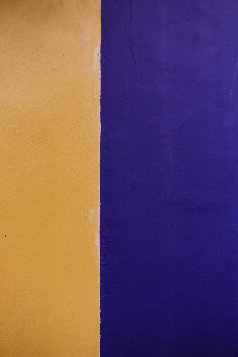 una pared amarilla y púrpura con un reloj