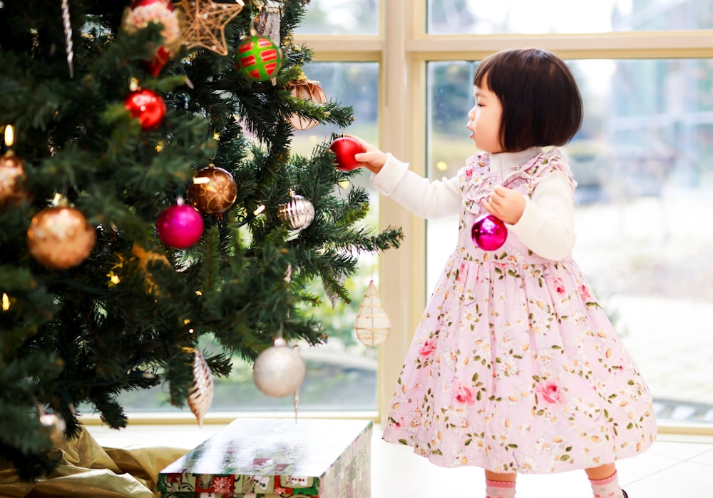 girl holding baubles near the Christmas