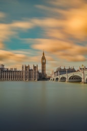 brown tower clock under cloudy sy