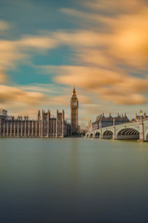 brown tower clock under cloudy sy