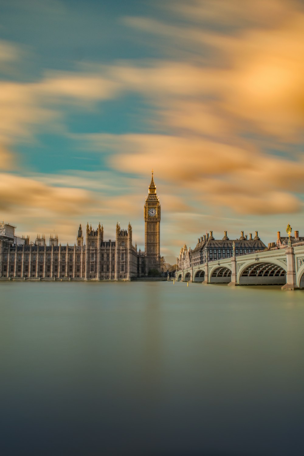 brown tower clock under cloudy sy