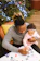 A child and parent coloring a vibrant Jesus-themed page at a cozy kitchen table.