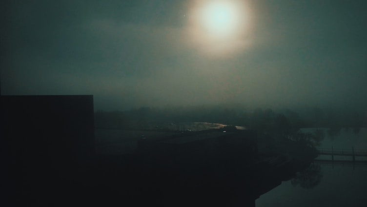 A mysterious dark fantasy landscape with shadowy figures and ancient ruins under a moonlit sky.