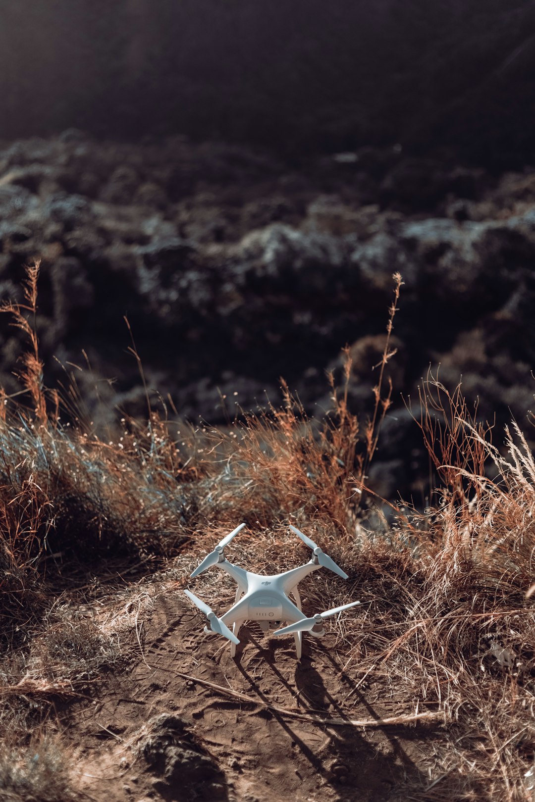 white quadcopter drone on brown grass