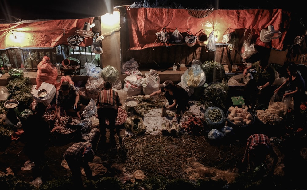 people standing near sacks during night time