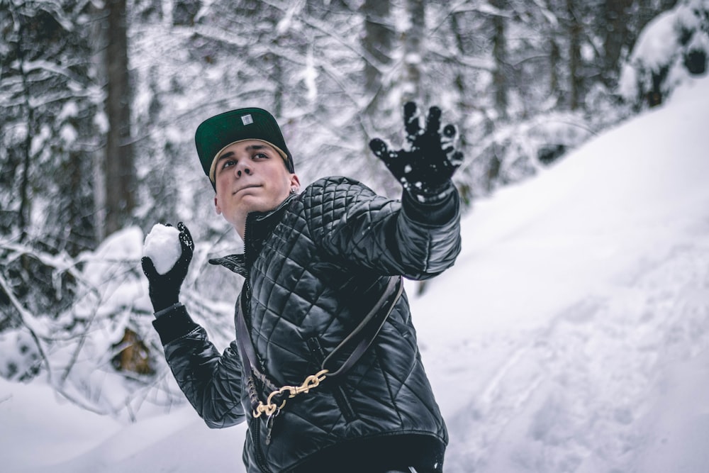 man holding snowball during daytime