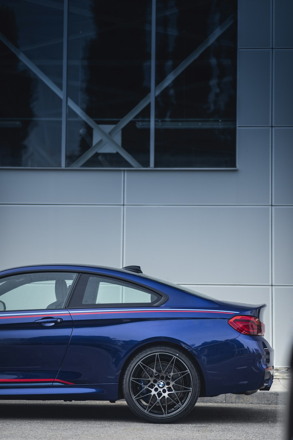 blue coupe parked near wall