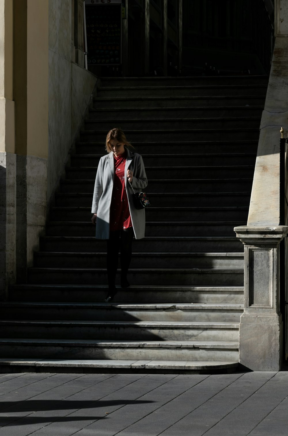 woman on stair wearing gray coat