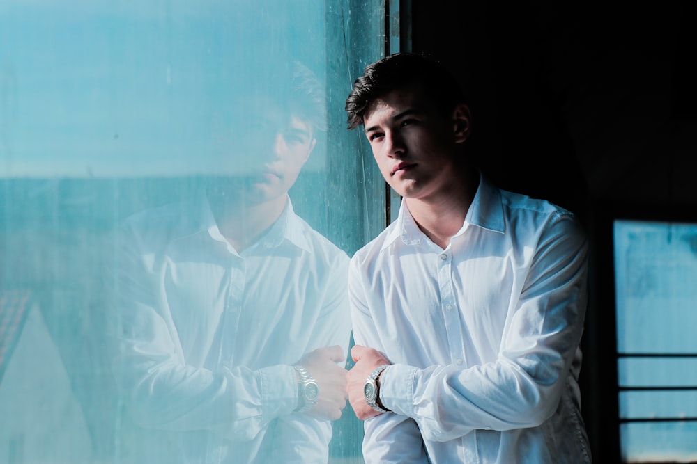 man leaning on glass wall