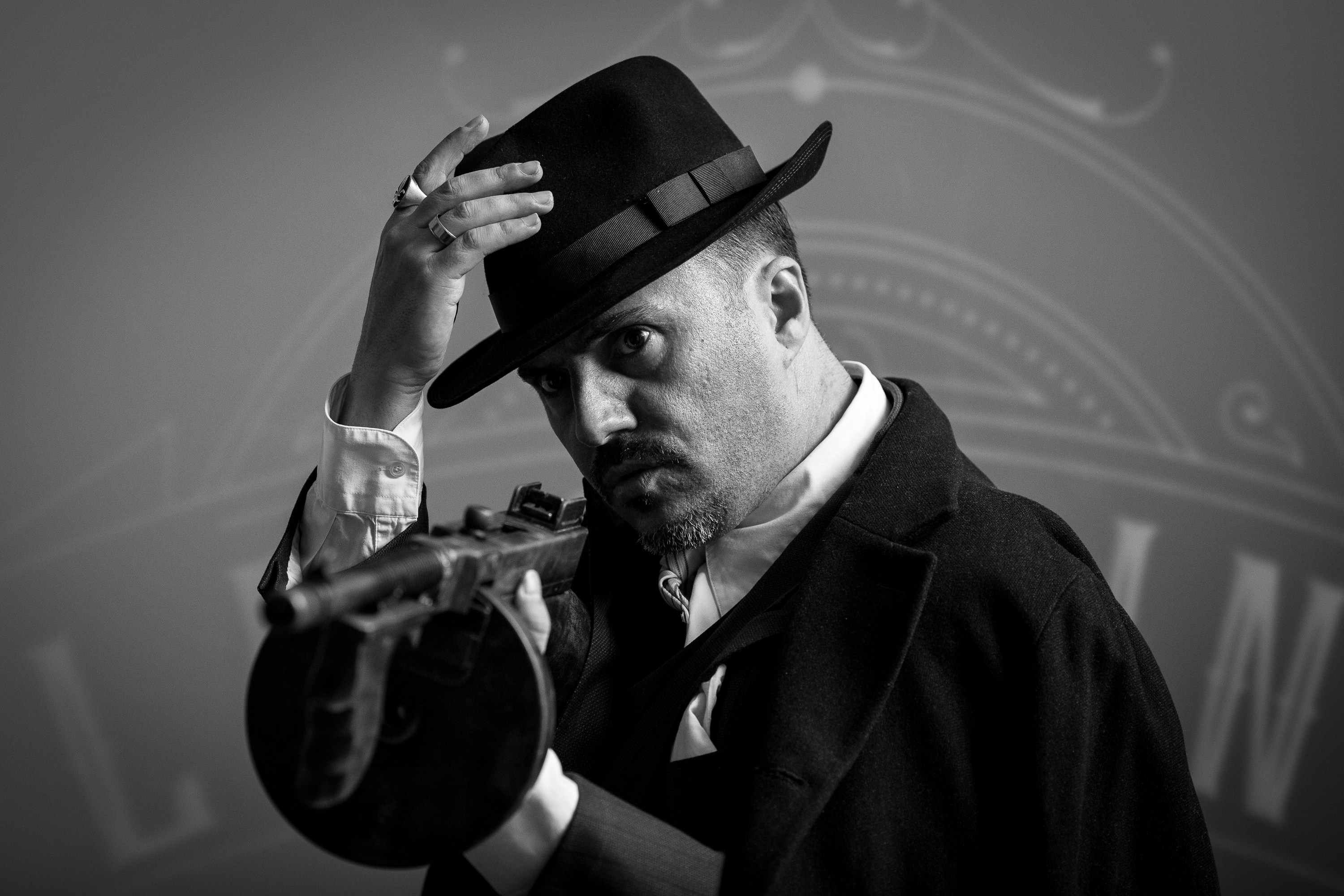 man holding his hat while holding rifle