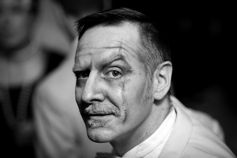 man with scar on face grayscale photography