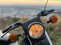 Close-up of a Suzuki motorcycle's dashboard with illuminated controls at dusk.