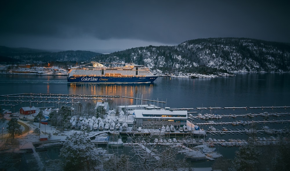 cruise ship near mountains and buildings during night