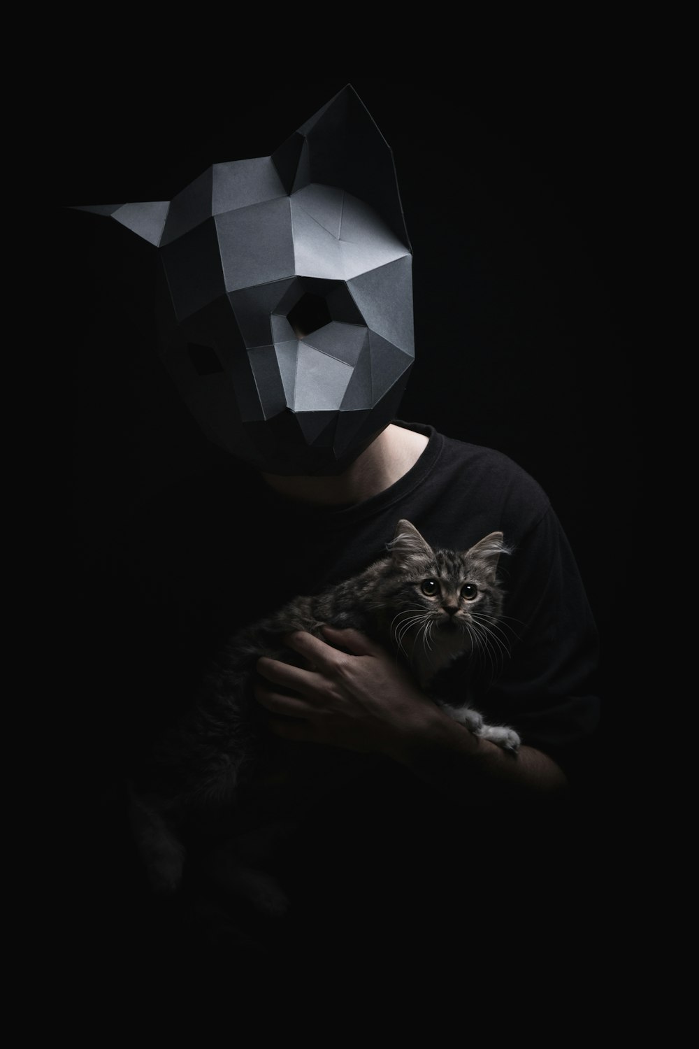 man with mask holding cat