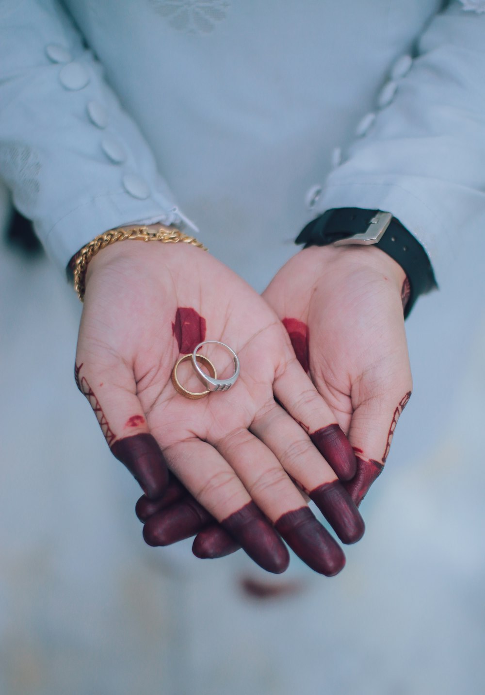 person holding silver-and-gold-colored rings