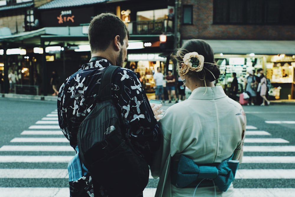 man and woman standing front of pedestrian lane