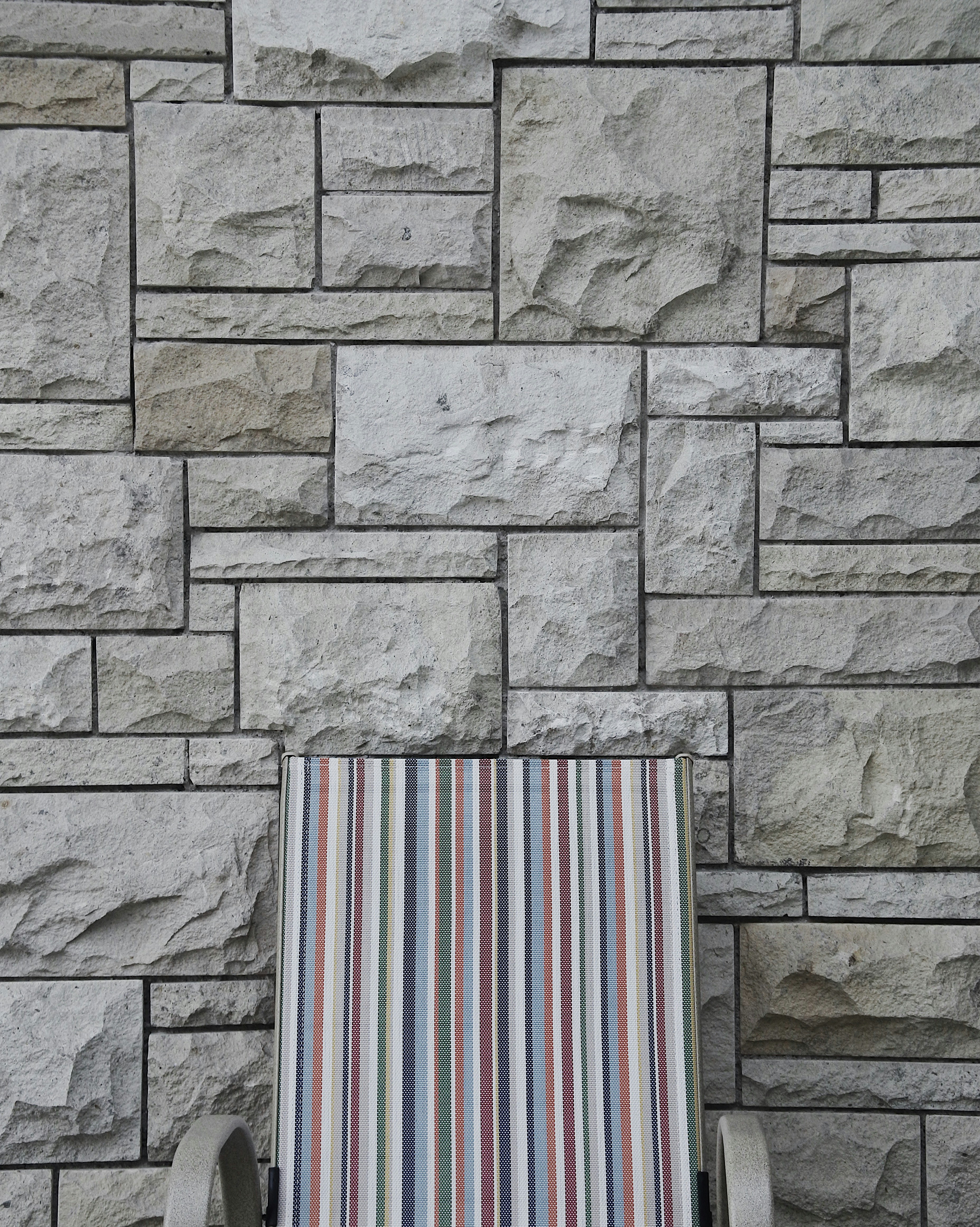 gray armchair near brick wall