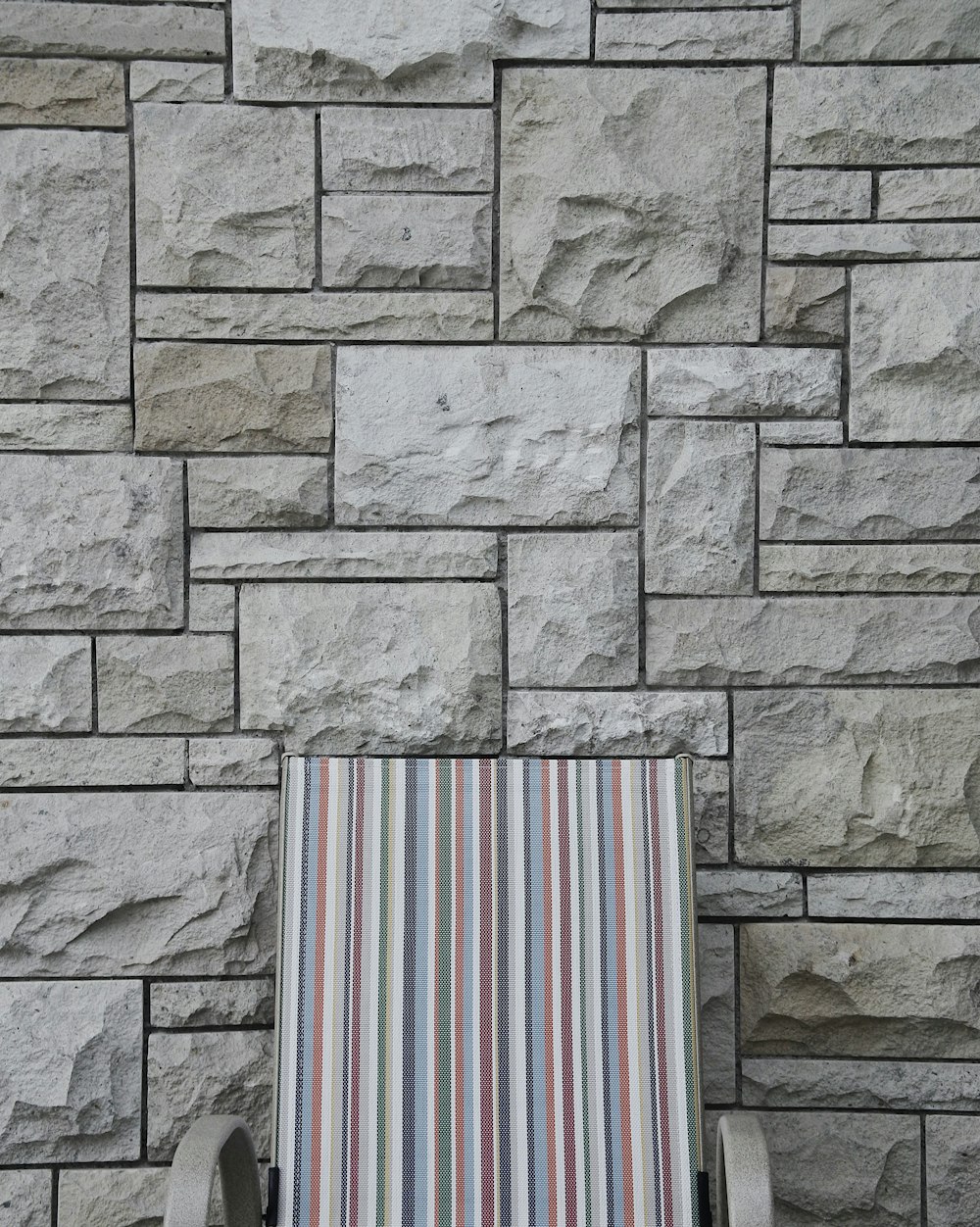 gray armchair near brick wall