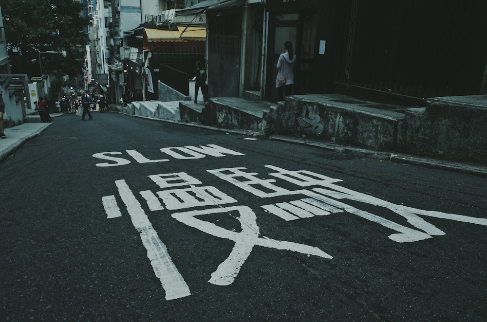 black asphalt road with slow text written