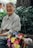 A joyful elderly woman smiling while holding a Medicare brochure in a sunny park.