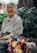 A joyful elderly woman smiling while holding a Medicare brochure in a sunny park.