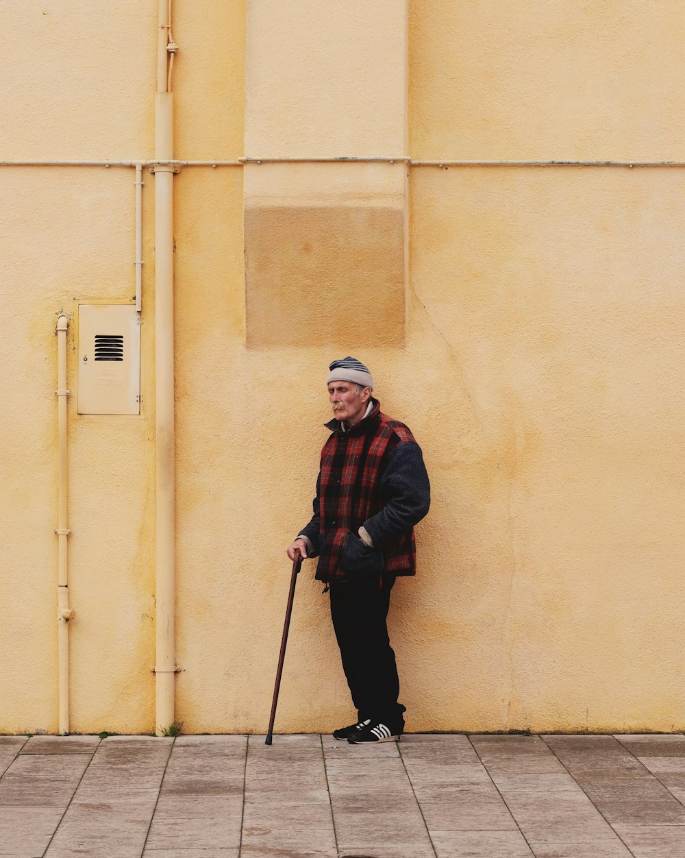 man standing yellow wall