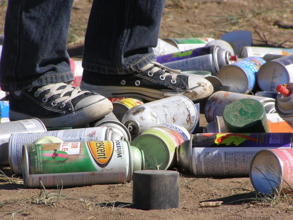 assorted paint spray cans on ground