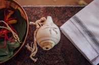 A serene setting showing a bowl of white flowers and a set of cowrie shells used for divination.