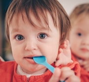 toddler putting spoon in mouth