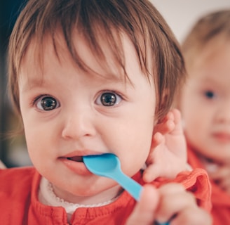 toddler putting spoon in mouth