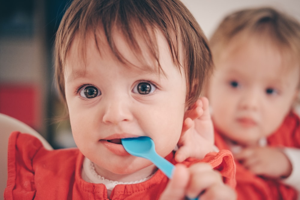 toddler putting spoon in mouth