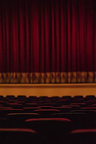 A cozy theater stage with warm lighting and an intimate audience setting.