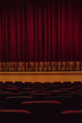 Actors performing on stage in an intimate theater setting.